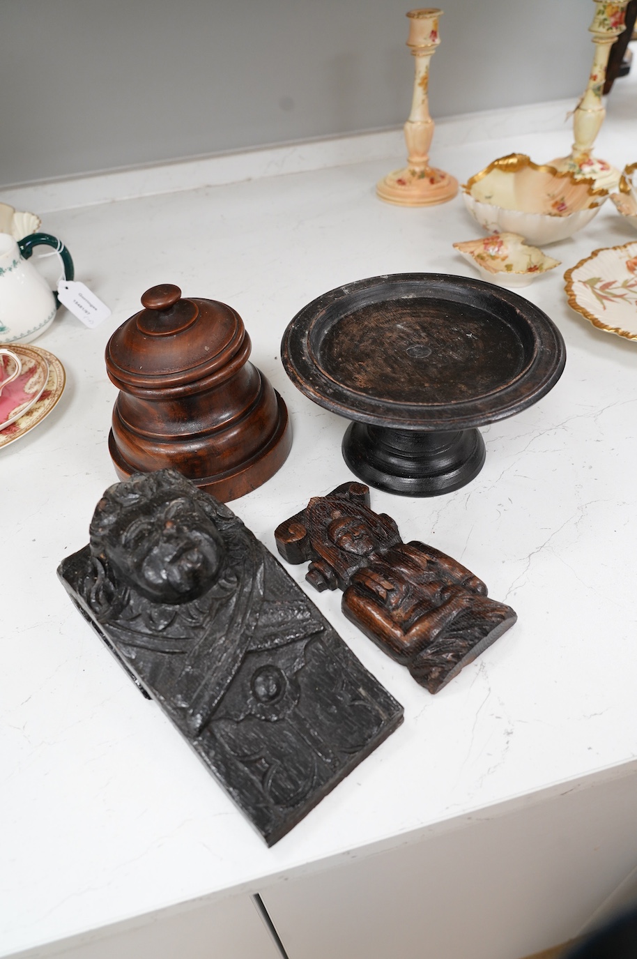 A 17th century carved oak mask corbel, another smaller, a small tazza and a carved wood pot and cover, tallest 19.5cm. Condition - fair to good